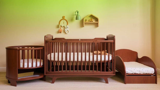 a convertible crib with a wooden frame and a white mattress. The crib has three detachable parts