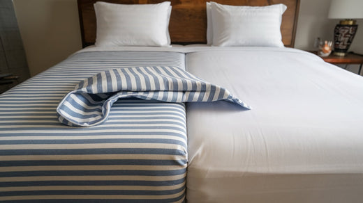 split king size sheets. There is a white bed with a blue and white striped sheet. 