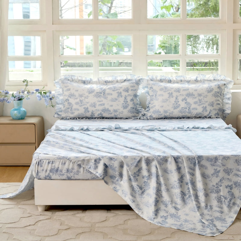 Bed with red floral patterned bedding in a bedroom setting.