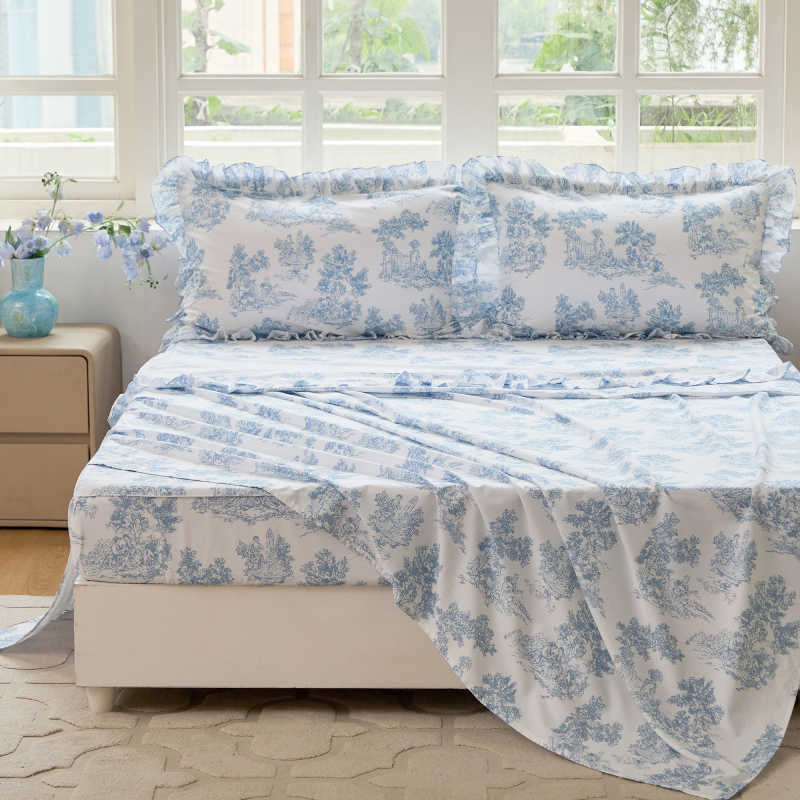 Bed with red floral patterned bedding in a bedroom setting.