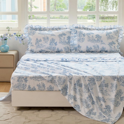 Bed with red floral patterned bedding in a bedroom setting.