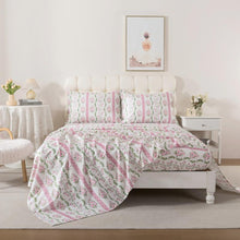 Bed with red floral patterned bedding in a bedroom setting.
