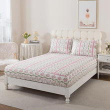 Bed with green floral patterned bedding in a bedroom setting
