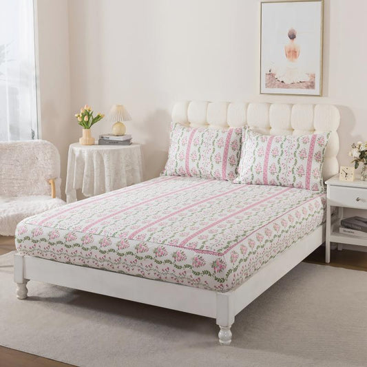 Bed with green floral patterned bedding in a bedroom setting