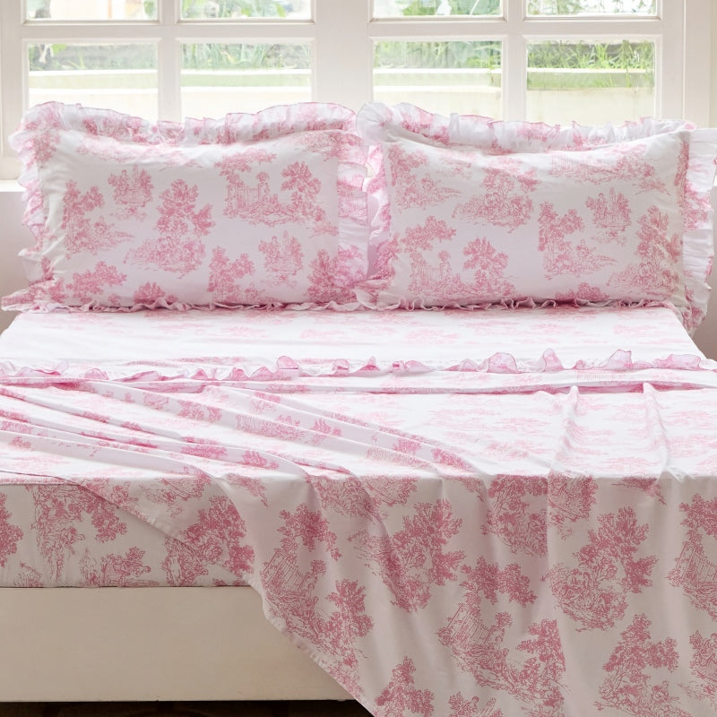 Bed with red floral patterned bedding in a bedroom setting.
