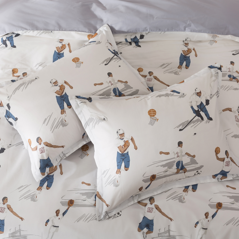 Two pillows on a bed with candles in the background.