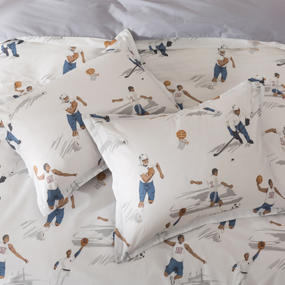 Two pillows on a bed with candles in the background.
