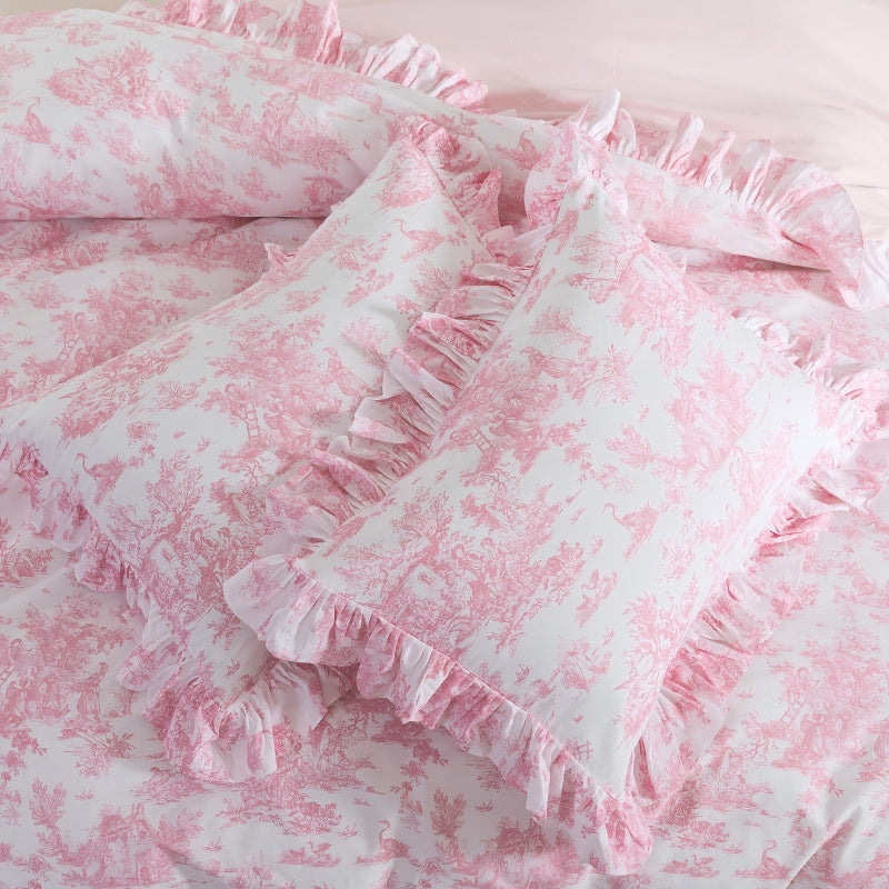 Two pillows on a bed with candles in the background.