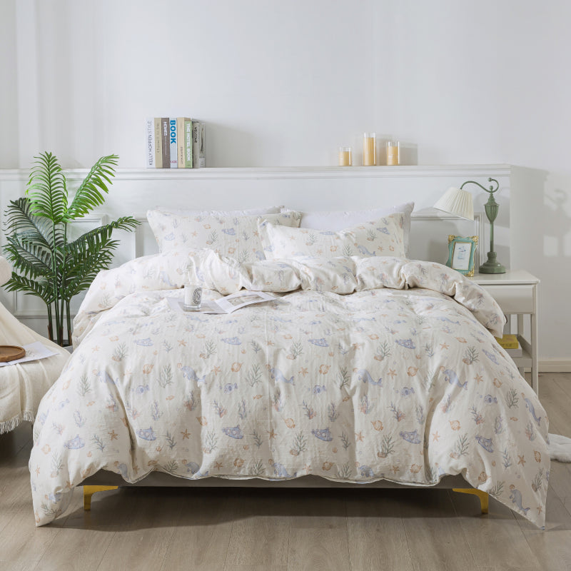 Floral-patterned comforter set on a bed in a bedroom with a plant and nightstand.