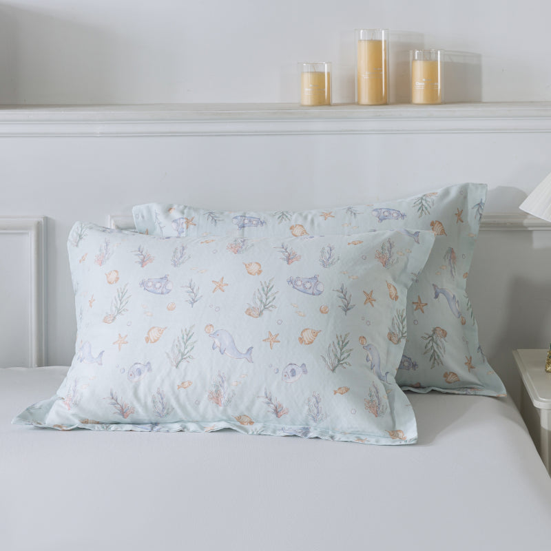 Floral patterned pillows on a bed with candles in the background