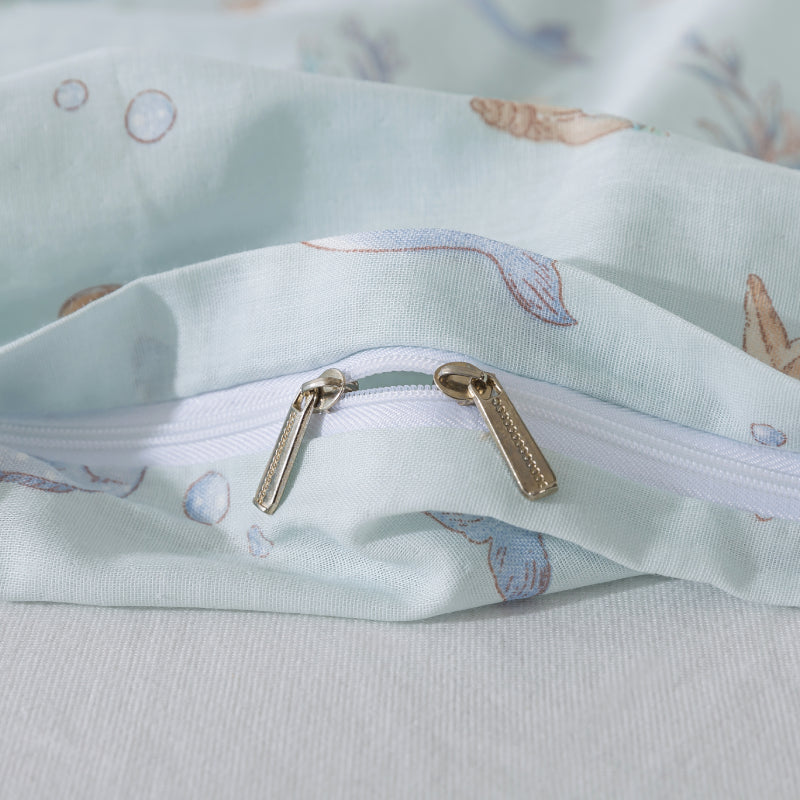 Close-up of a fabric bag with a zipper and shell pattern on a light blue background
