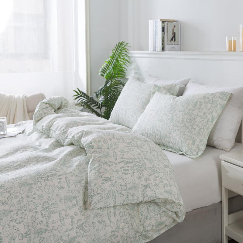 Bedroom with floral-patterned bedding and a plant