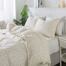 Bed with floral-patterned bedding in a bright bedroom setting