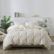 Neatly made bed with white comforter in a bright bedroom setting